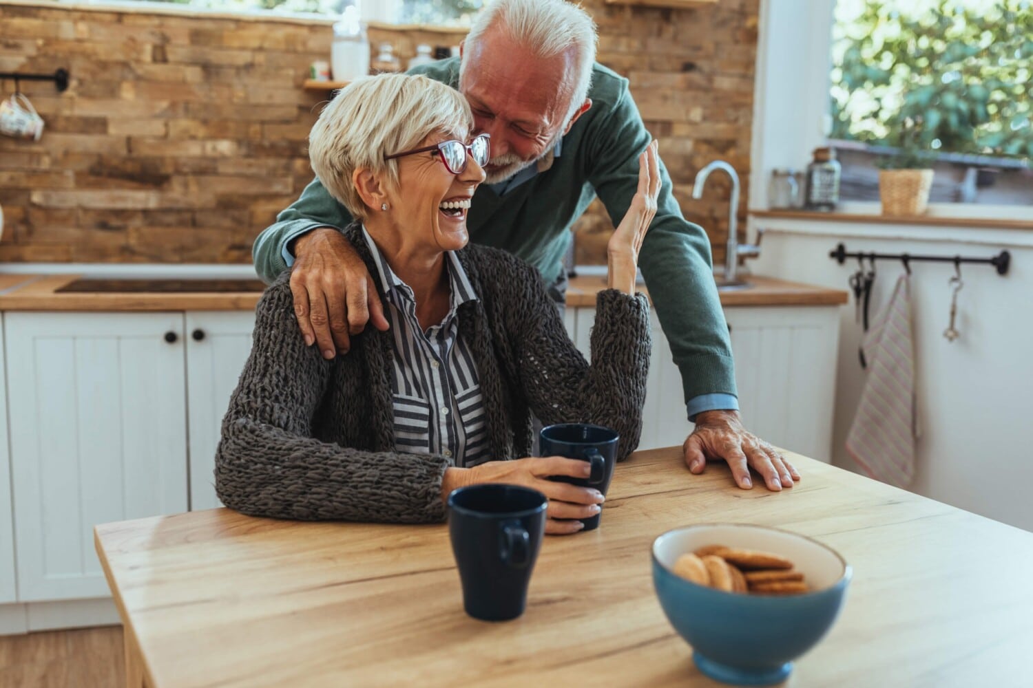 healthy and happy senior couple laughing in kitchen